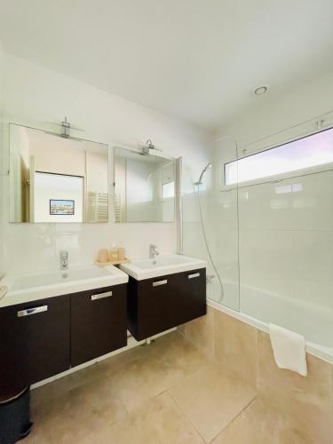 une salle de bain avec deux lavabos et une douche dans l'établissement Le Domaine de la Montagnette, à La Teste-de-Buch