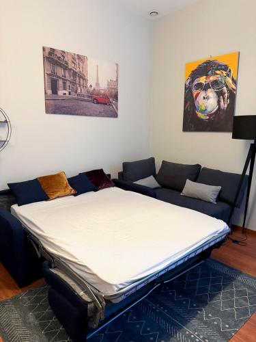 - un lit dans un salon avec un canapé dans l'établissement Studio Lumineux Proche Centre et Port, à Port-Vendres