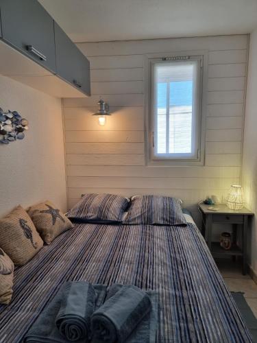 a bedroom with a bed with two pillows on it at A La Plage in Leucate