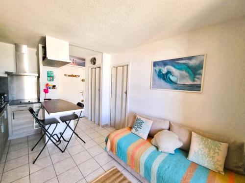 a living room with a couch and a kitchen at A La Plage in Leucate