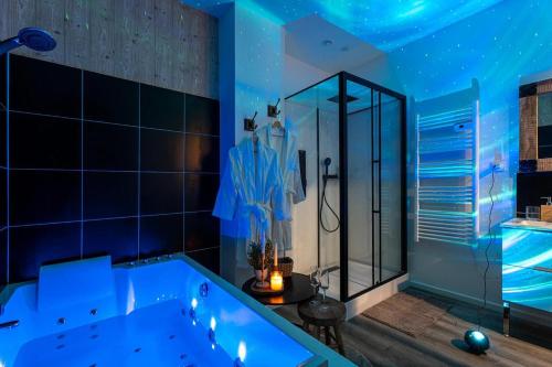 ein blaues Bad mit einer Badewanne und einer Dusche in der Unterkunft Le Nid Douillet, Center, Jacuzzi, Sensory Shower in Bordeaux