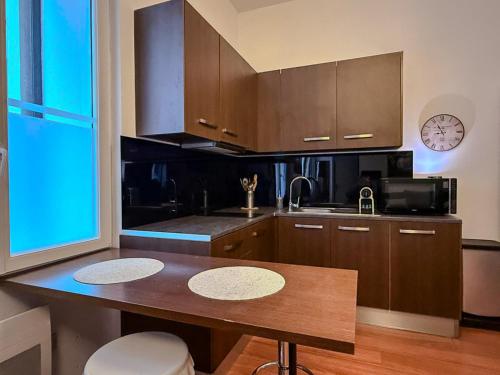 a kitchen with brown cabinets and a wooden table at Studio Lumineux Proche Centre et Port in Port-Vendres