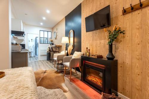 Elle comprend un salon avec une cheminée et une télévision murale. dans l'établissement Le Nid Douillet, Center, Jacuzzi, Sensory Shower, à Bordeaux