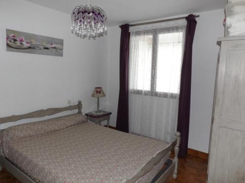 une chambre avec un lit et un lustre dans l'établissement Les logis de Magali les Zodiacs, terrasse, plage à 600m, à Argelès-sur-Mer