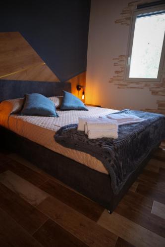 a bedroom with a bed with blue pillows and a window at White House R&B in Campobello di Licata