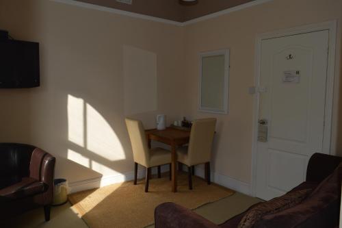a living room with a table and two chairs at The Sheldon B&B - FREE private parking in Eastbourne
