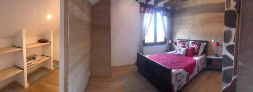 - une chambre avec un lit avec des draps roses et une fenêtre dans l'établissement Entre lac et montagne, à Faverges