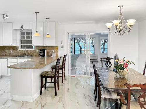 a kitchen with a table and chairs and a dining room at Baywatch Paradice Bayfront, private pier, Sleeps 8 Fenced Dog Area 8 m to beach in Gulf Shores