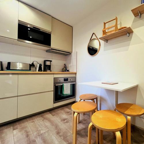 une cuisine avec une table, deux chaises et un comptoir dans l'établissement Le 13, à Cassis