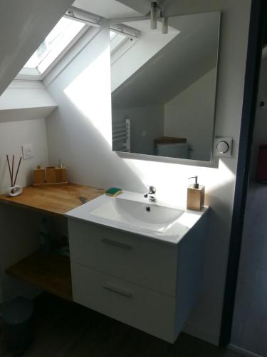 une salle de bain avec un lavabo et un miroir dans l'établissement Charmant appartement, calme, nature et confort, à Uzerche