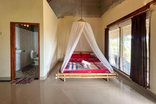 a bedroom with a hammock in the corner of a room at Melody Ekas Lombok in Ekas