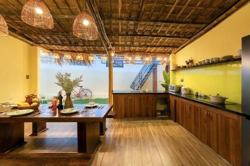 a kitchen with a wooden table and a large window at Dan Linh Homestay in An Bang