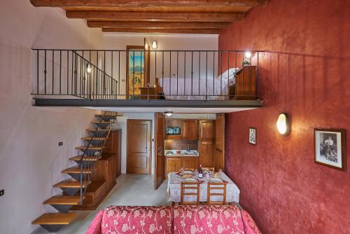 a living room with a bed and a staircase at Casanova - Family Apartments Residence in San Quirico dʼOrcia