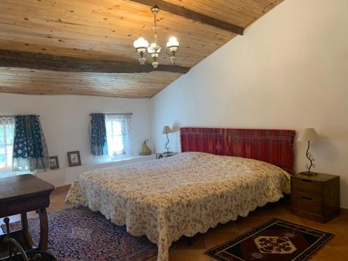 une chambre avec un lit et un plafond en bois dans l'établissement Mas ancien sans vis-à-vis avec piscine chauffé dans les collines, à Les Pilles