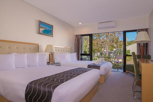 Säng eller sängar i ett rum på Paihia Pacific Resort Hotel
