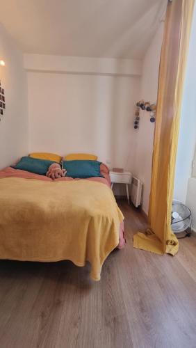 une chambre avec un lit avec une couverture jaune dessus dans l'établissement Charmant Type 2 hyper centre, à Corte