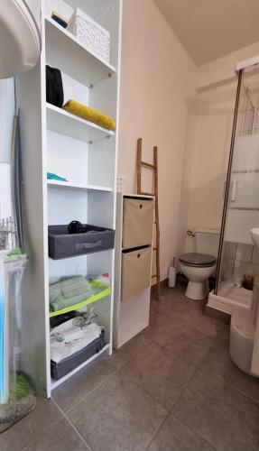 une salle de bain avec une étagère blanche et des toilettes dans l'établissement Charmant Type 2 hyper centre, à Corte