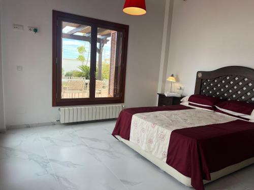 a bedroom with a large bed and a window at Modern 3 Bedroom Villa with Pool & Garden, Ideal for Families in Lo Mendigo