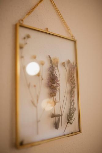 a framed picture of dried flowers on a wall at ALPENHOF Westerbuchberg in Übersee