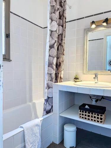 une salle de bain avec un lavabo, une baignoire et un miroir dans l'établissement Mini Villa Santa Giulia double vue mer à 5 min de la plage à pied, à Porto-Vecchio