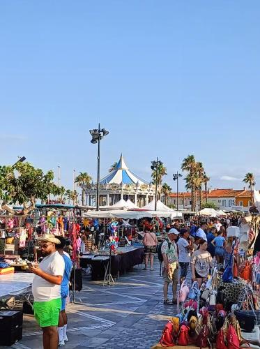 Un groupe de personnes se promenant autour d'un marché en plein air dans l'établissement Hacienda, au Barcarès