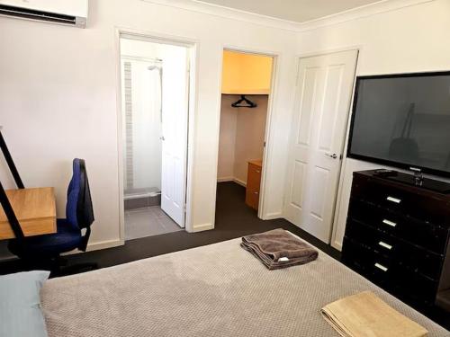 a bedroom with a bed and a television and a chair at Quiet house in Bedford in Perth