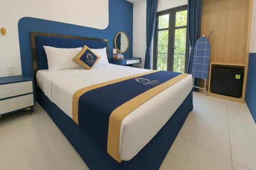 a bedroom with a blue and white bed and a television at Arina Luxury Hotel - Vincom Tay Ninh in Tây Ninh