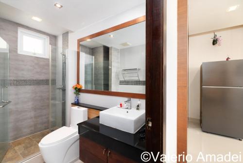 a bathroom with a sink and a toilet and a mirror at Sea & Sky Karon Beach by PHR in Karon Beach