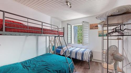 une chambre avec deux lits superposés et une fenêtre dans l'établissement V-Passerelle 01-Vieux Boucau Jolie maison proche océan et plage avec terrasse ensoleillée, à Vieux-Boucau-les-Bains