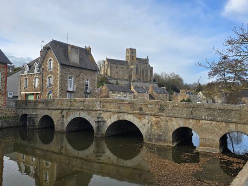 a bridge over a river with a castle in the background at Kyriad Hôtel Lamballe - Gare TGV - Centre ville in Lamballe