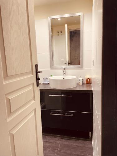 une salle de bain avec un lavabo et un miroir dans l'établissement Paris 4U, à Paris