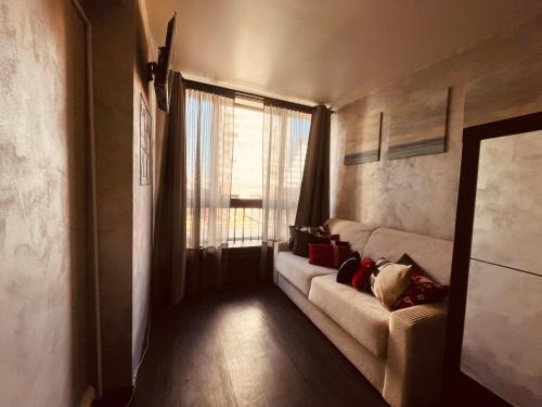 un salon avec un canapé et une fenêtre dans l'établissement Paris 4U, à Paris