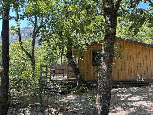 une cabane dans les bois avec des arbres dans l'établissement Camping Les Cent Chênes, à Saint-Jeannet
