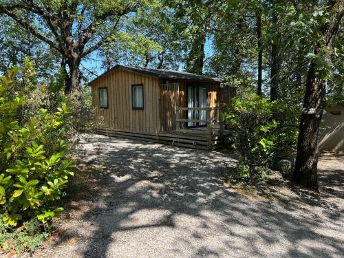 une cabane en bois au milieu d'une forêt dans l'établissement Camping Les Cent Chênes, à Saint-Jeannet