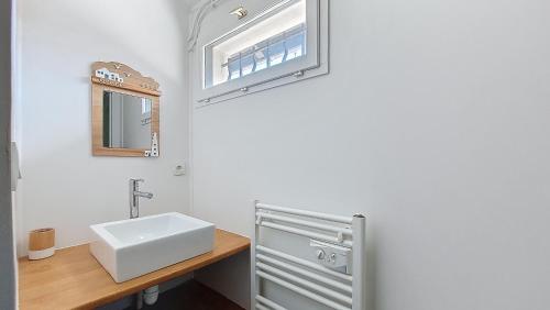 une salle de bain avec un lavabo blanc et un miroir dans l'établissement V-Passerelle 01-Vieux Boucau Jolie maison proche océan et plage avec terrasse ensoleillée, à Vieux-Boucau-les-Bains