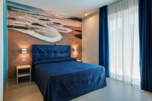 a bedroom with a blue bed and a painting on the wall at Hotel La Sorgente HS in Paestum