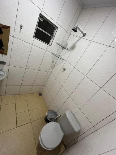 a bathroom with a toilet and a shower with a window at Toca da Onça in Coronel José Diaz