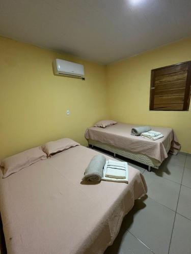 two beds in a room with yellow walls at Toca da Onça in Coronel José Diaz