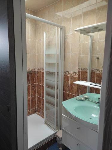 La salle de bains est pourvue d'une douche avec un lavabo et une porte de douche en verre. dans l'établissement Mimi, à Quend