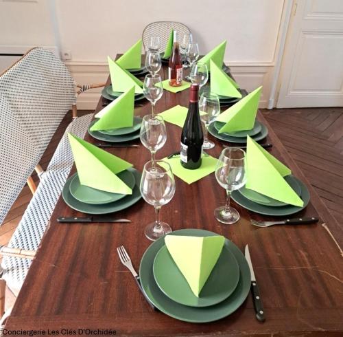 une table dressée avec des assiettes vertes et des verres à vin dans l'établissement L'Escapade en Loire, à Saumur