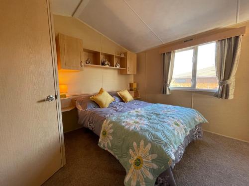 a bedroom with a bed and a window at Cambrian Rio Caravan in Ynys-lâs Station