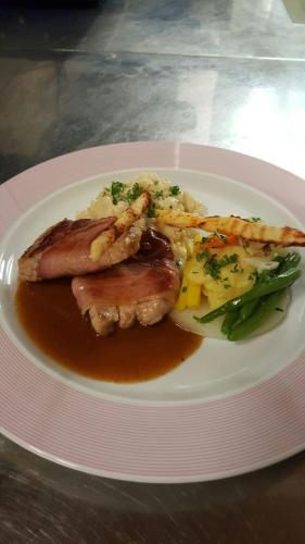 a plate of food with meat and vegetables on a table at Hotel Restaurant Cristal in Braunwald