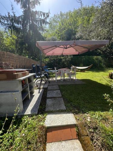 a patio with a table and a pink umbrella at Oasi degli ulivi in Luni