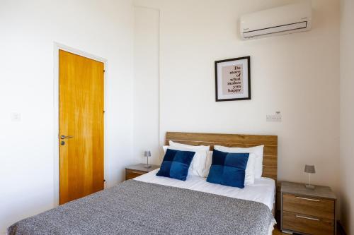 a bedroom with a bed with blue pillows at Villa Olympia in Nea Dimmata