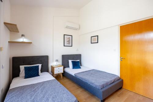 two beds in a small room with blue and white at Villa Olympia in Nea Dimmata
