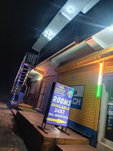 a sign in front of a building at night at Shivalik Home stay in Kanatal