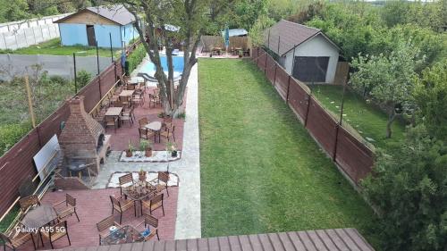 an empty backyard with a fence and tables and chairs at La Plantă-Therme Airport Bucharest in Baloteşti
