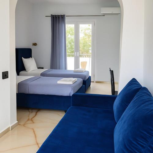 a room with two beds and a blue couch at Hotel Corali in (( Spile ))