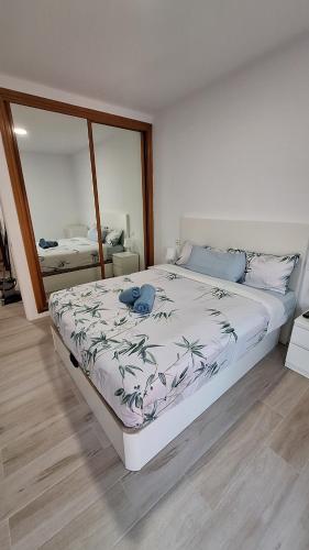 Un dormitorio con una cama grande y un espejo grande. en Perla 5, primera línea de playa y centrico, en Fuengirola