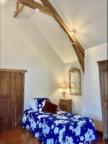 - une chambre avec un lit doté d'une couverture bleue fleurie dans l'établissement Maison 2 chambres avec espace extérieur privé et petit-déjeuner en supplément - fait-maison et produits locaux, à Vierville-sur-Mer